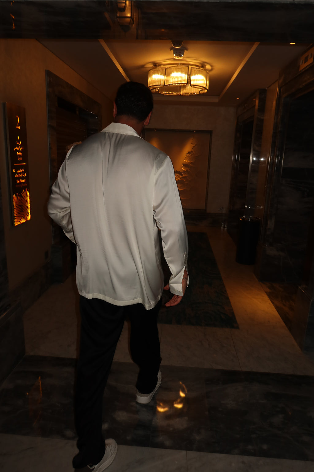 black silk trousers and a white silk shirt