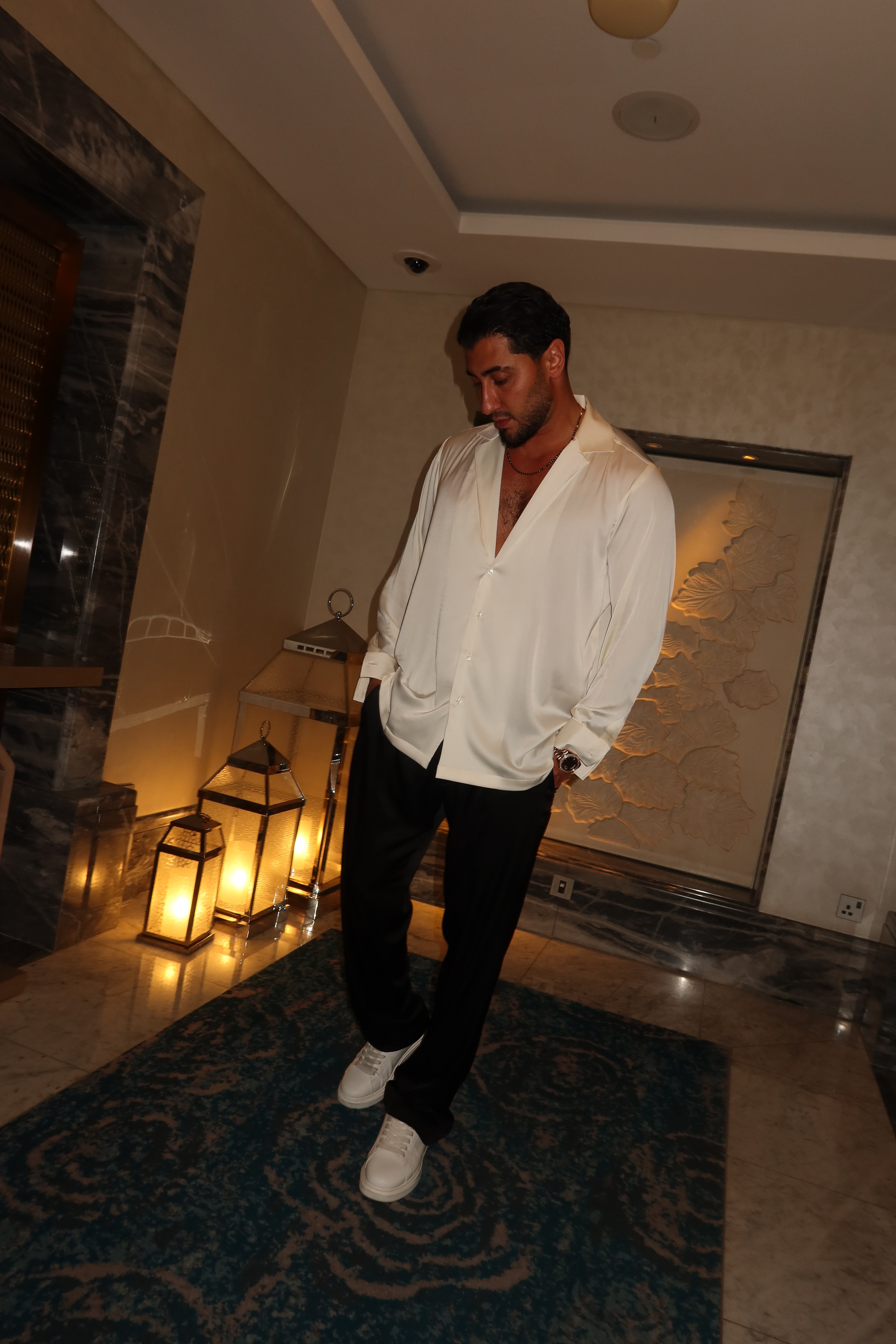 black silk trousers and a white silk shirt